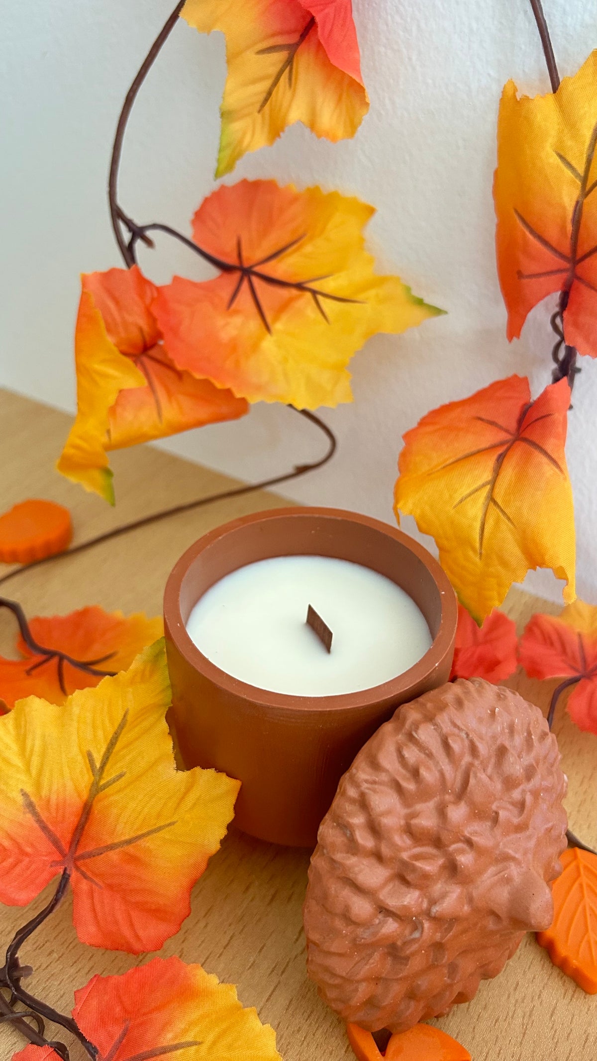Chênéa - bougie en pot chêne terracotta parmi les feuilles d'automne - Cocon by Héléa